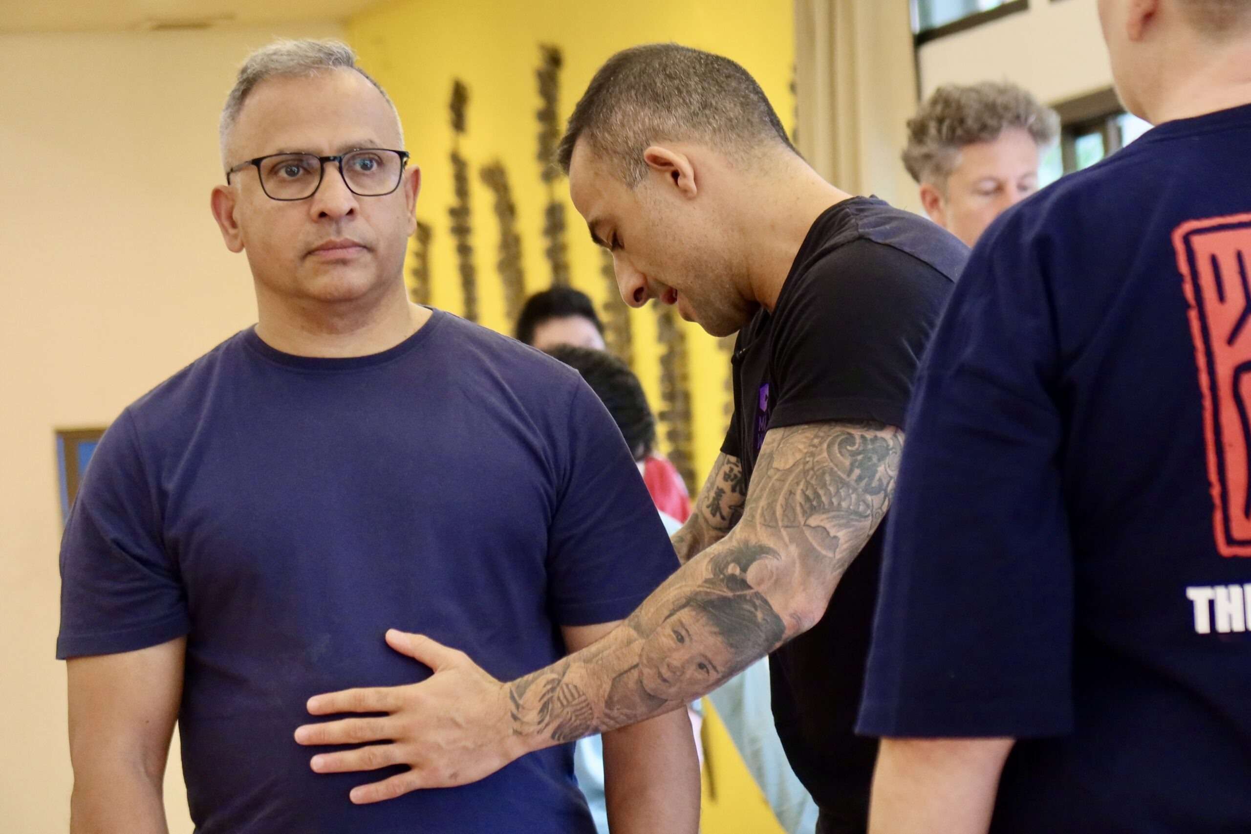 A practitioner places his hand on a participant’s chest to feel his structure